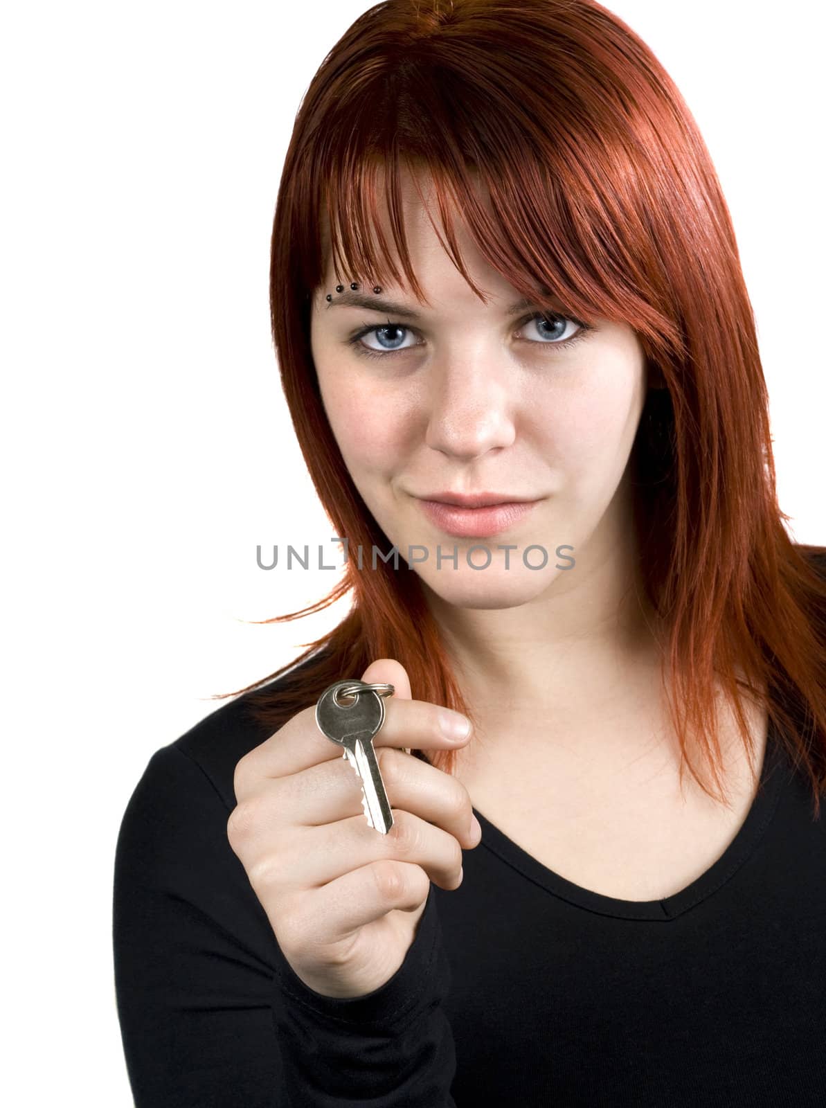 Cute redhead girl holding a key in her hands.

Studio shot.