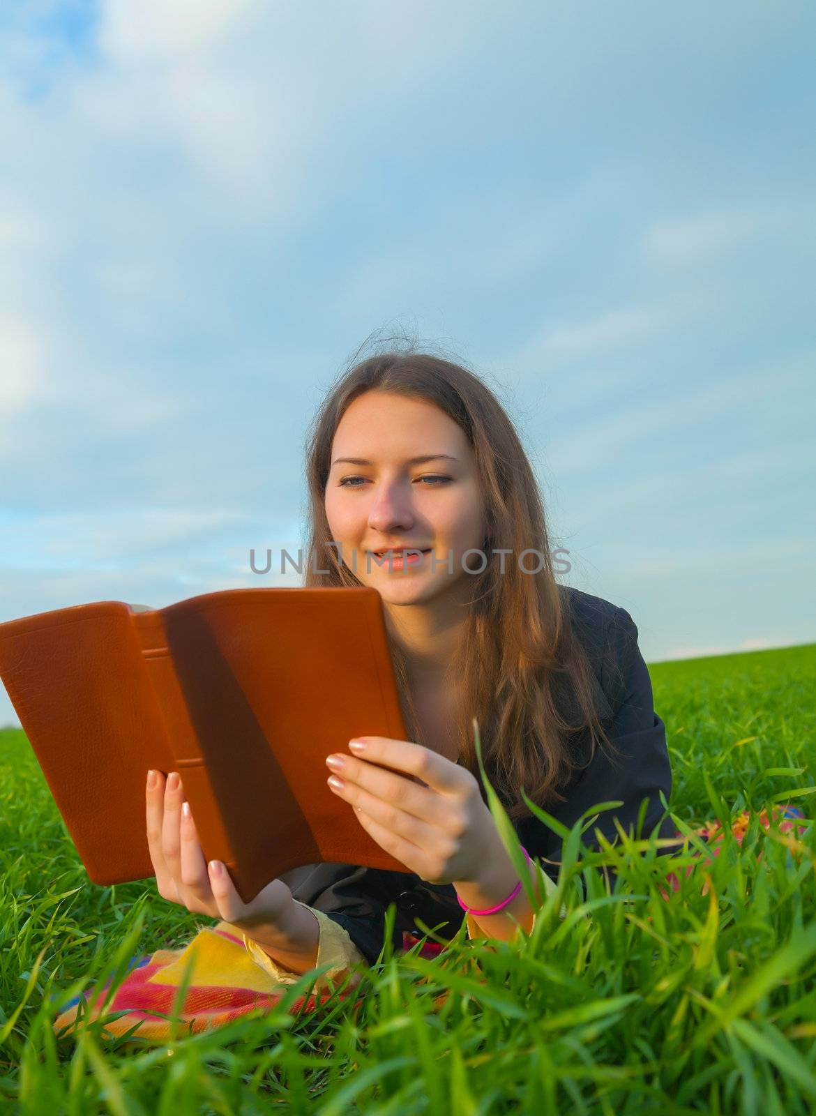 Teen girl reading the Bible outdoors by AndreyKr