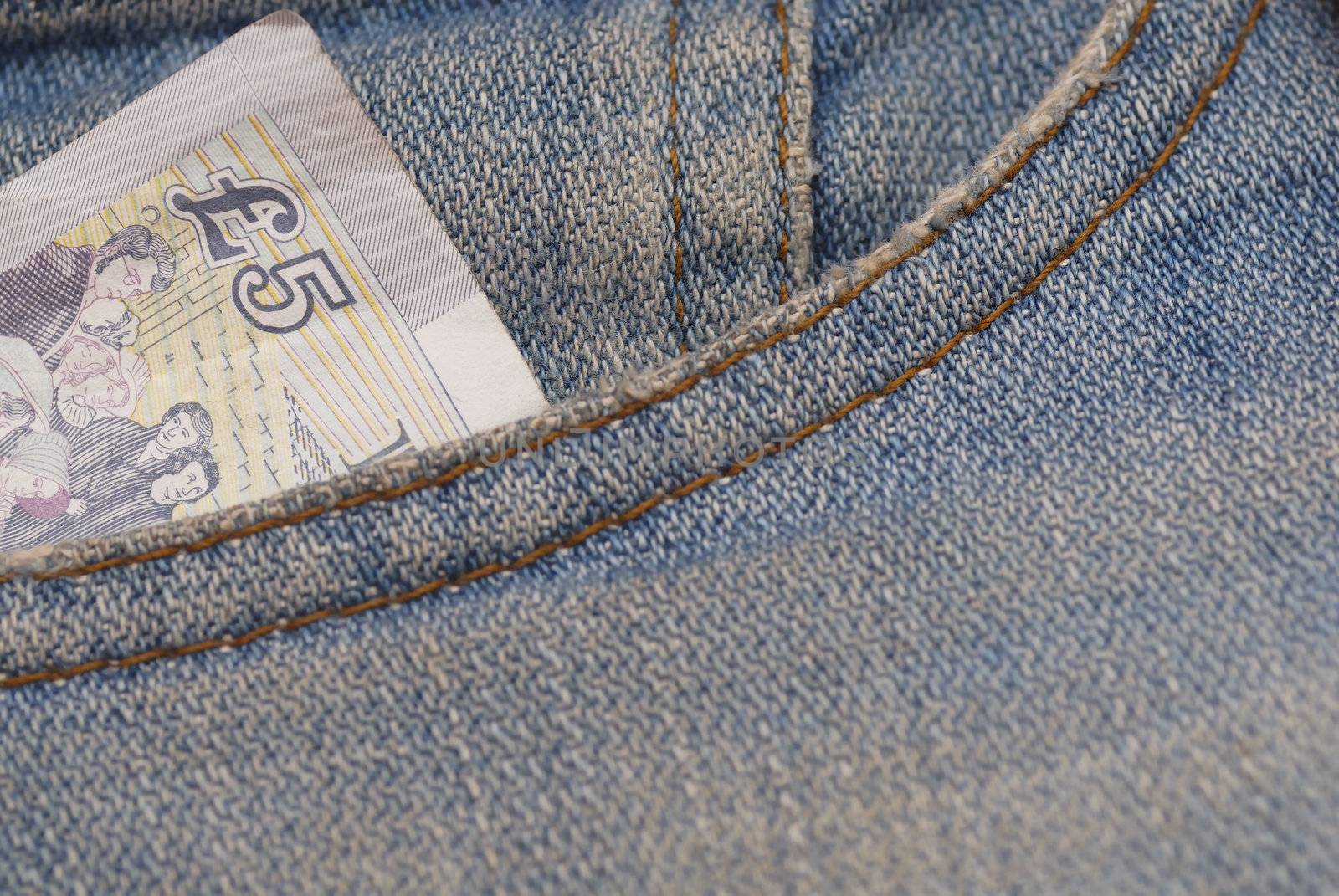 Macro photograph of �5 sterling in a Jeans pocket.