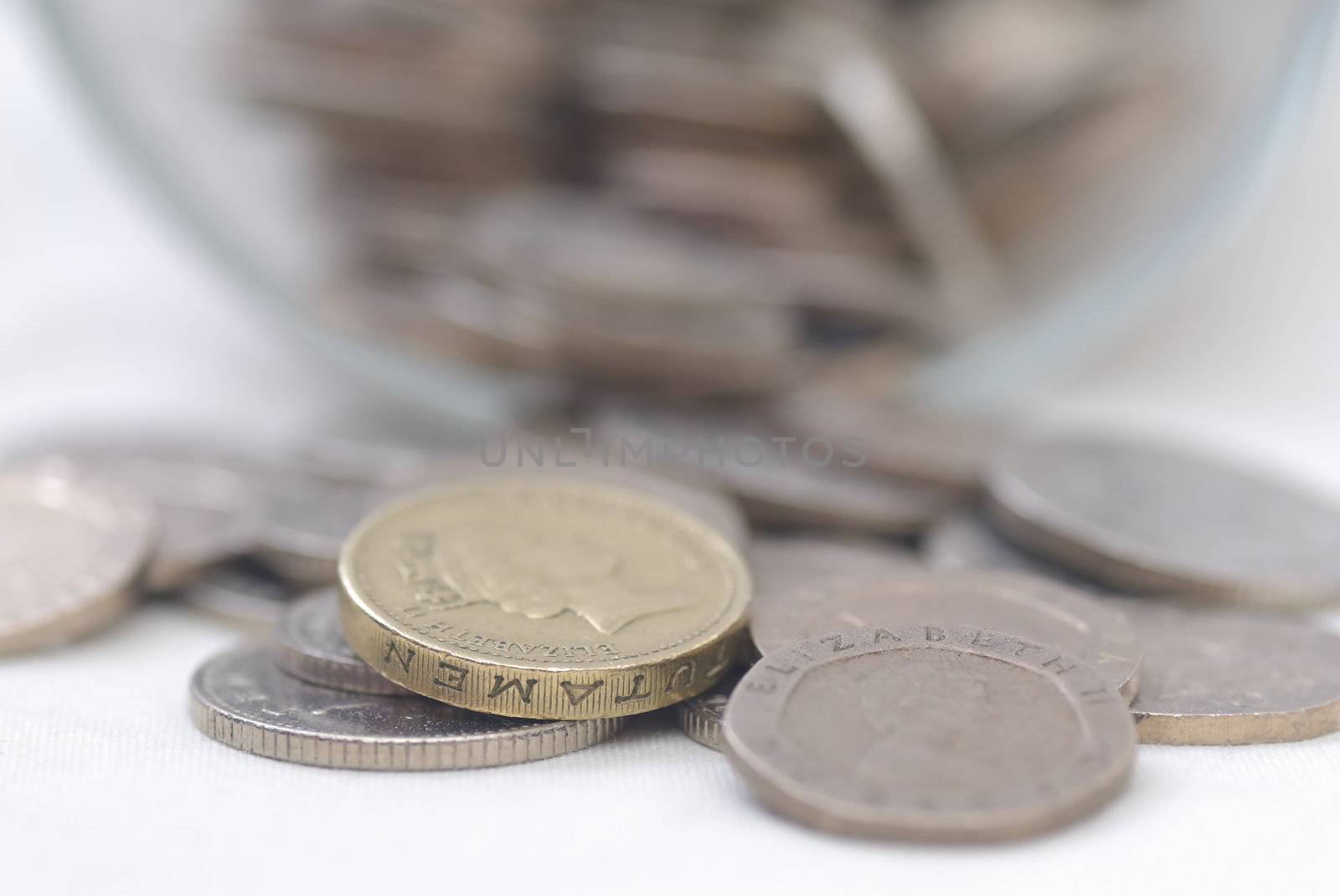 Spilled Coins from Glass Jar, focus on �1 coin. Sterling.