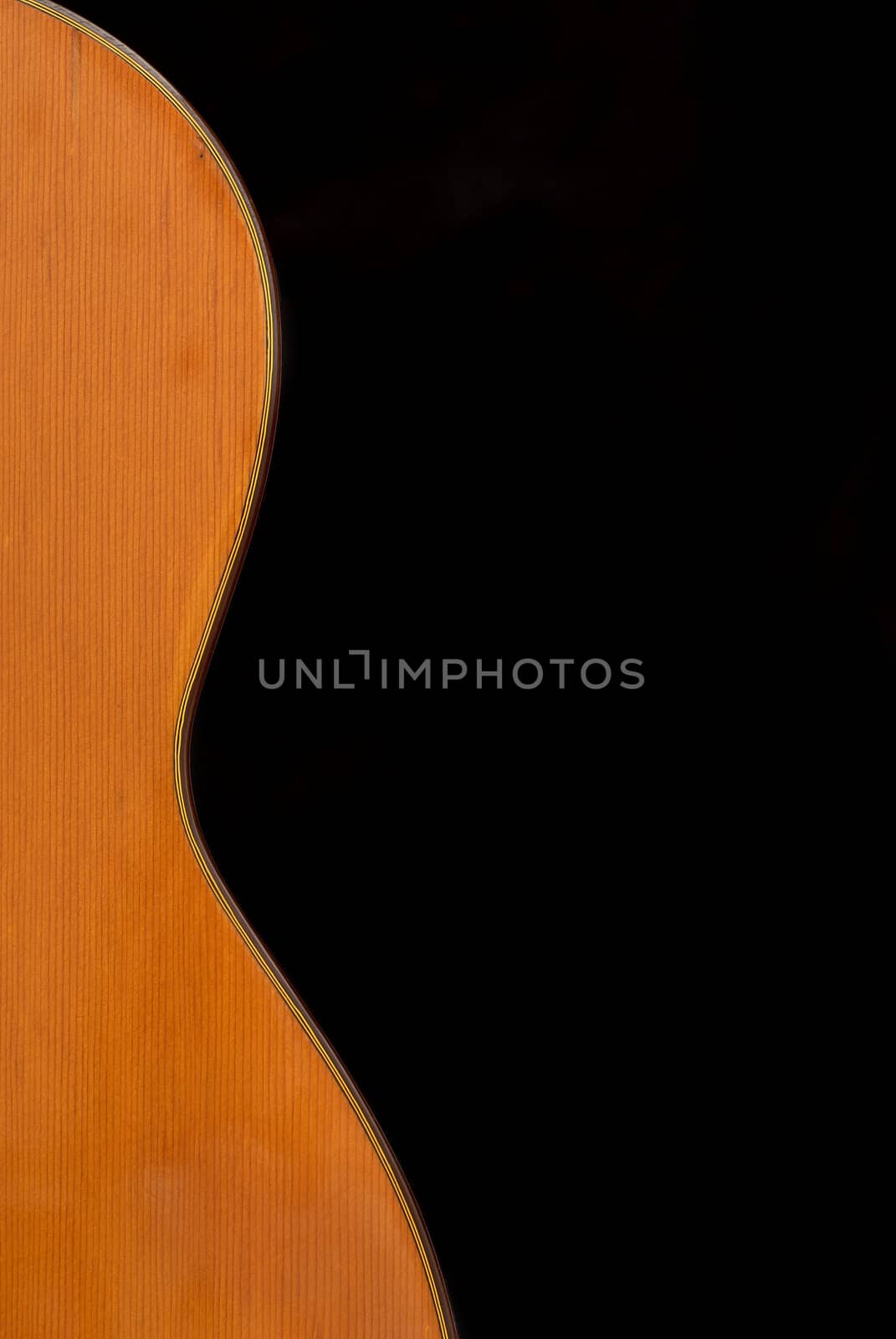 Detail of classic guitar (Spanish), against black background.