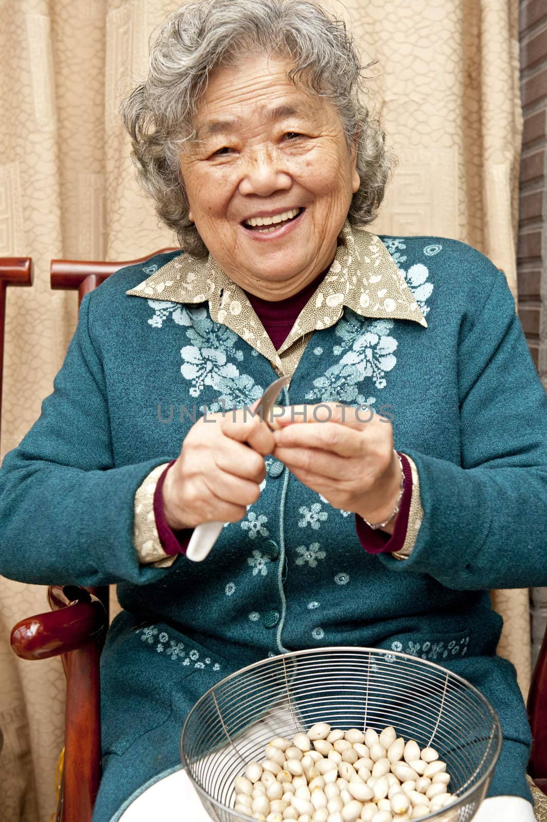 Grandmother peeling nut fruit