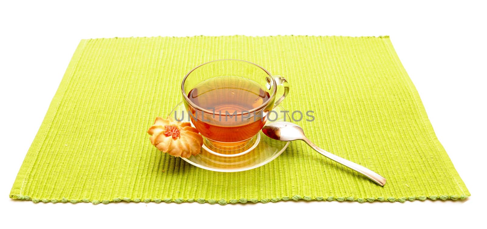 the cup of tea with spoon on the green napkin