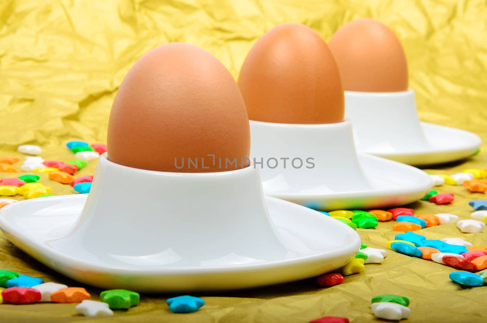 Colorful stars three eggs and egg cups are paper background