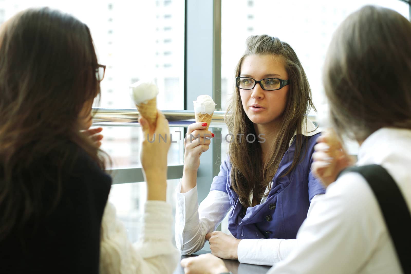 happy smiling women on foreground licking ice cream 