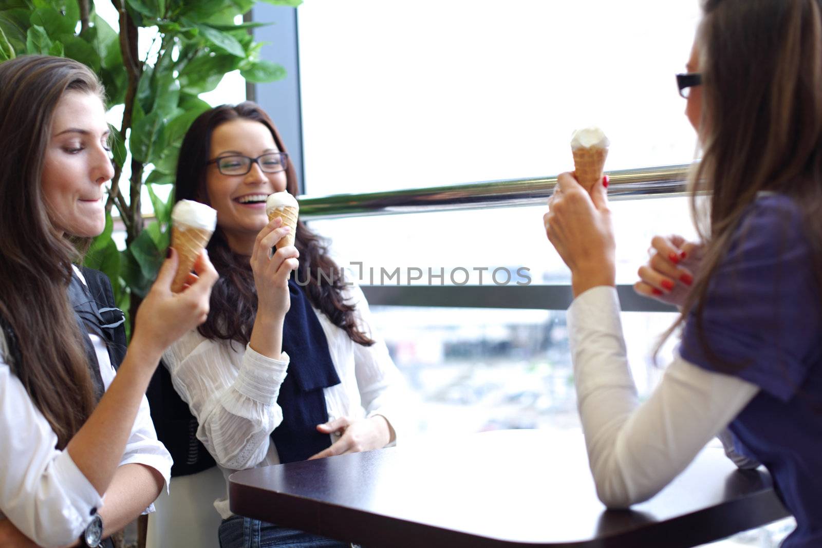 women on foreground licking ice cream 