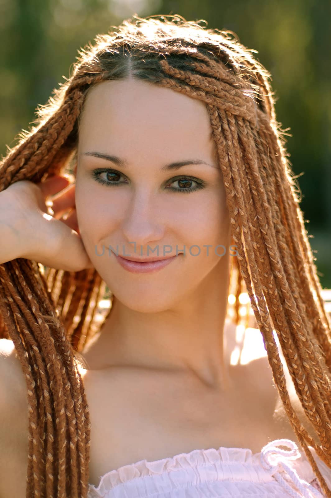 Beautiful girl with pigtails in the park summer morning