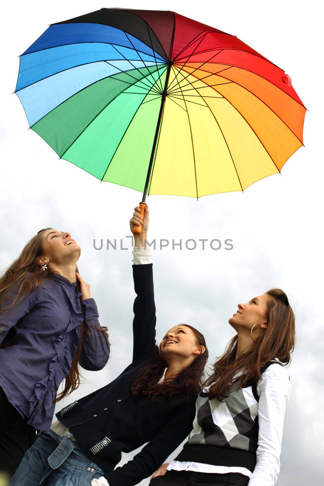 girlfriends stay under colourful umbrella 