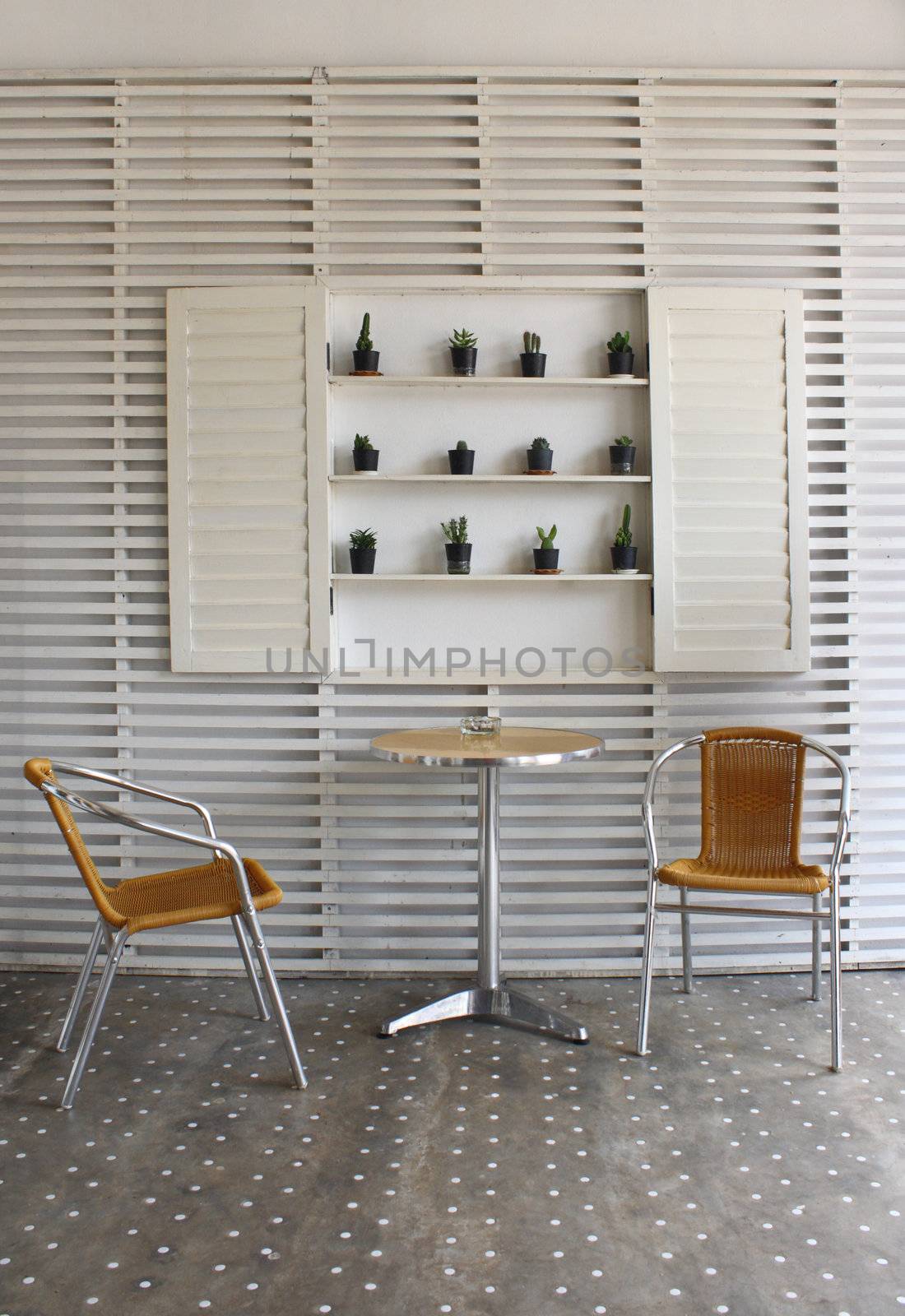 Table and chairs with white wood wall