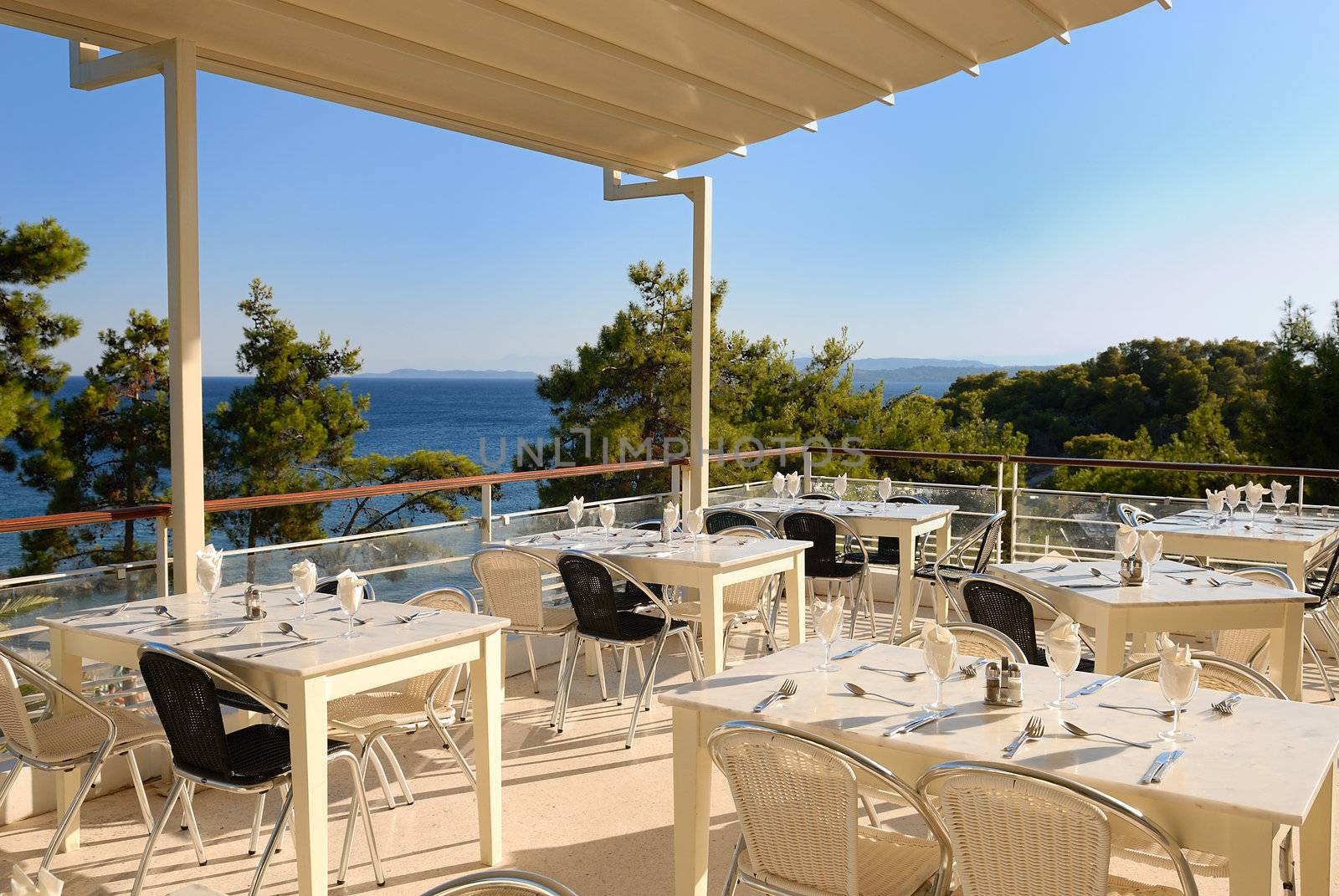 view of empty outdoor restaurant on the seashore, greece 