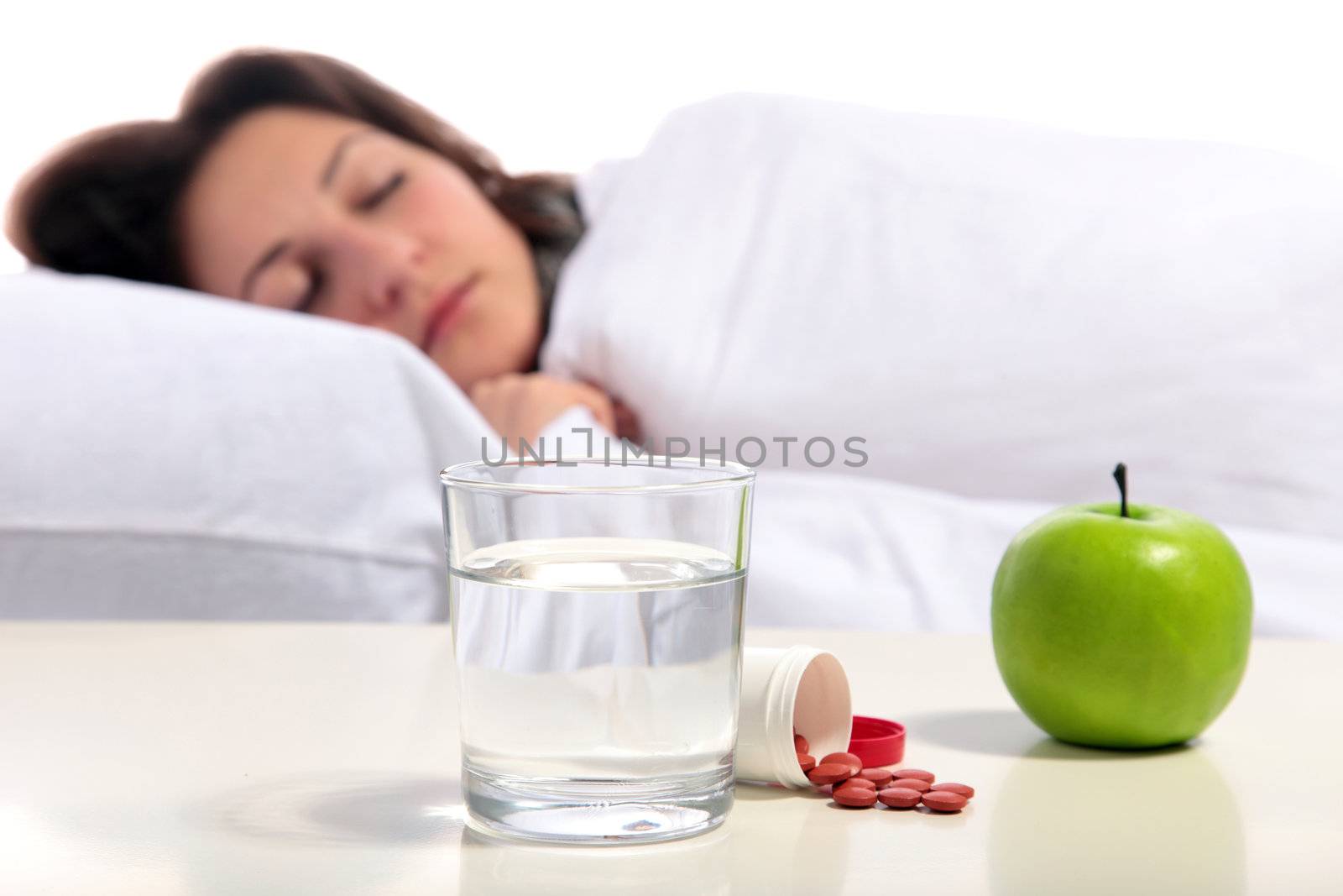 A young woman lying in the bed. All isolated on white background.