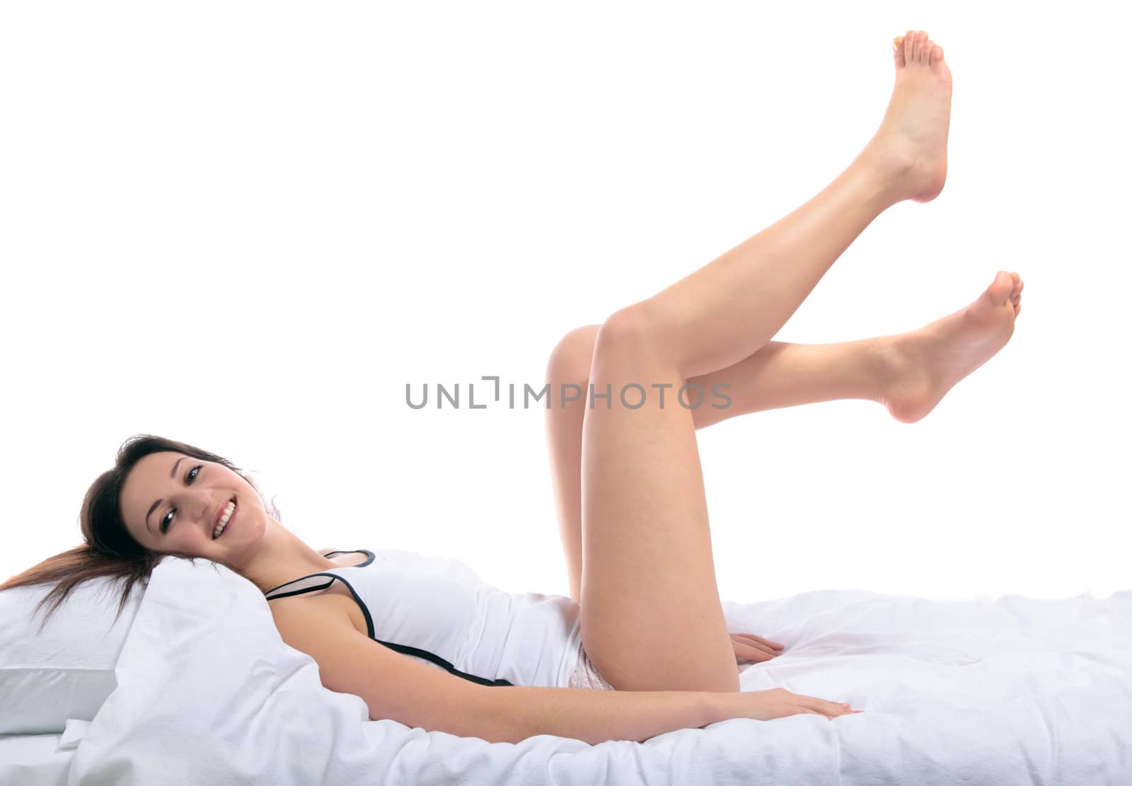 An awake young woman lying on her bed. All on white background.