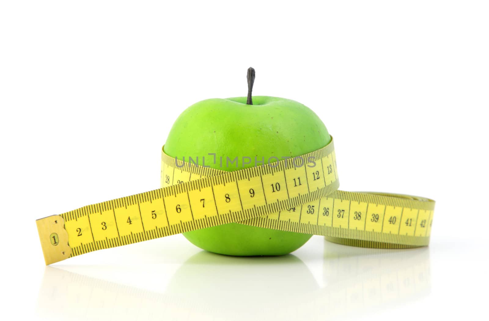 A fine green apple with a measuring tape symbolizing diet. All on white background.