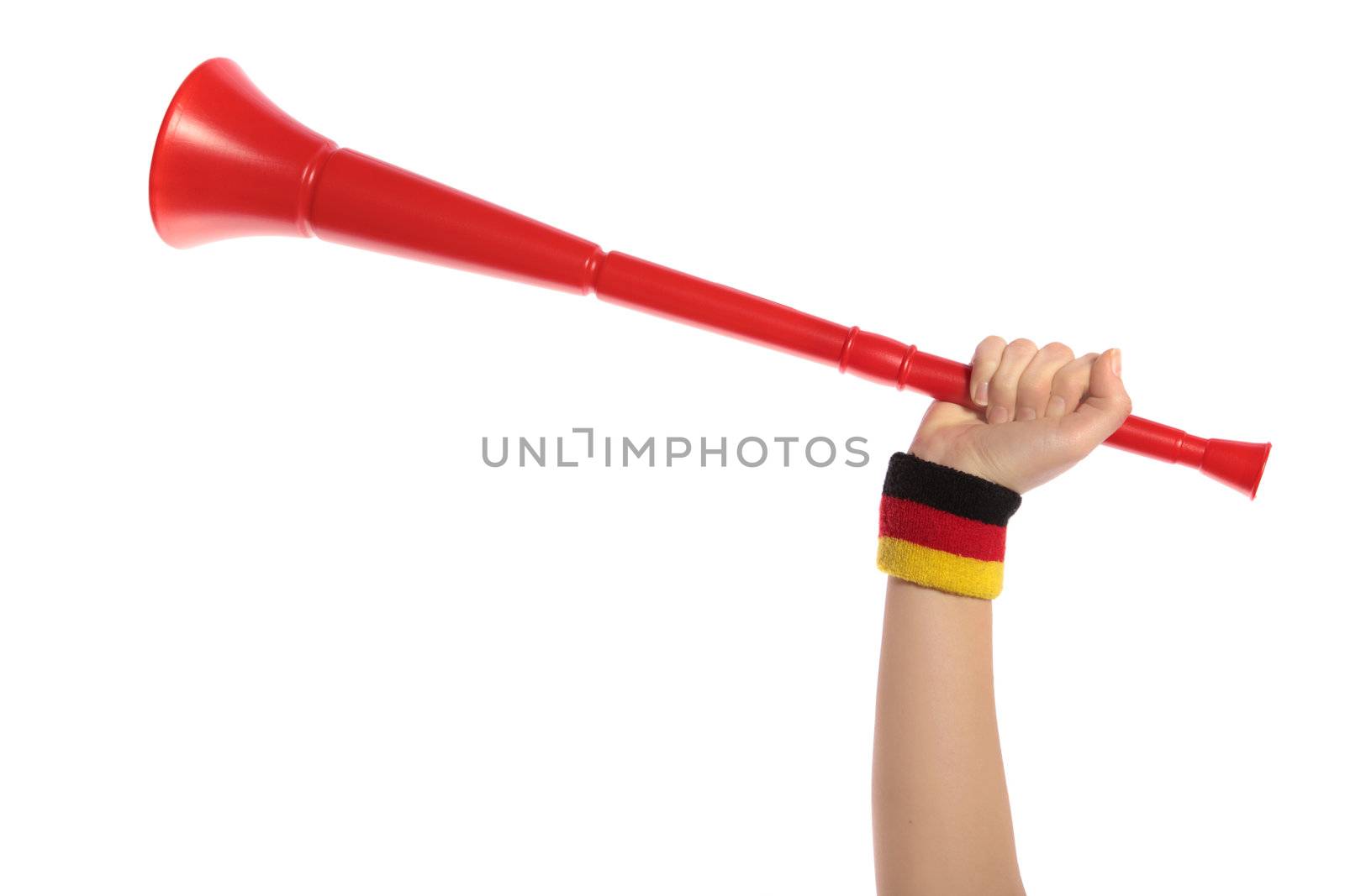 A human hand with a sweatband in german colors holding a vuvuzela, the traditional trumpet of south african supporters.