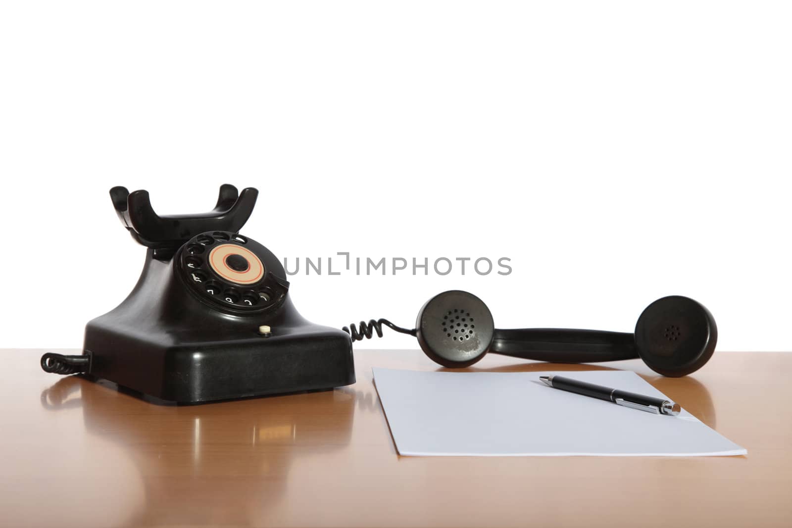 An old-fashioned telephone on a desk. All isolated on white background.