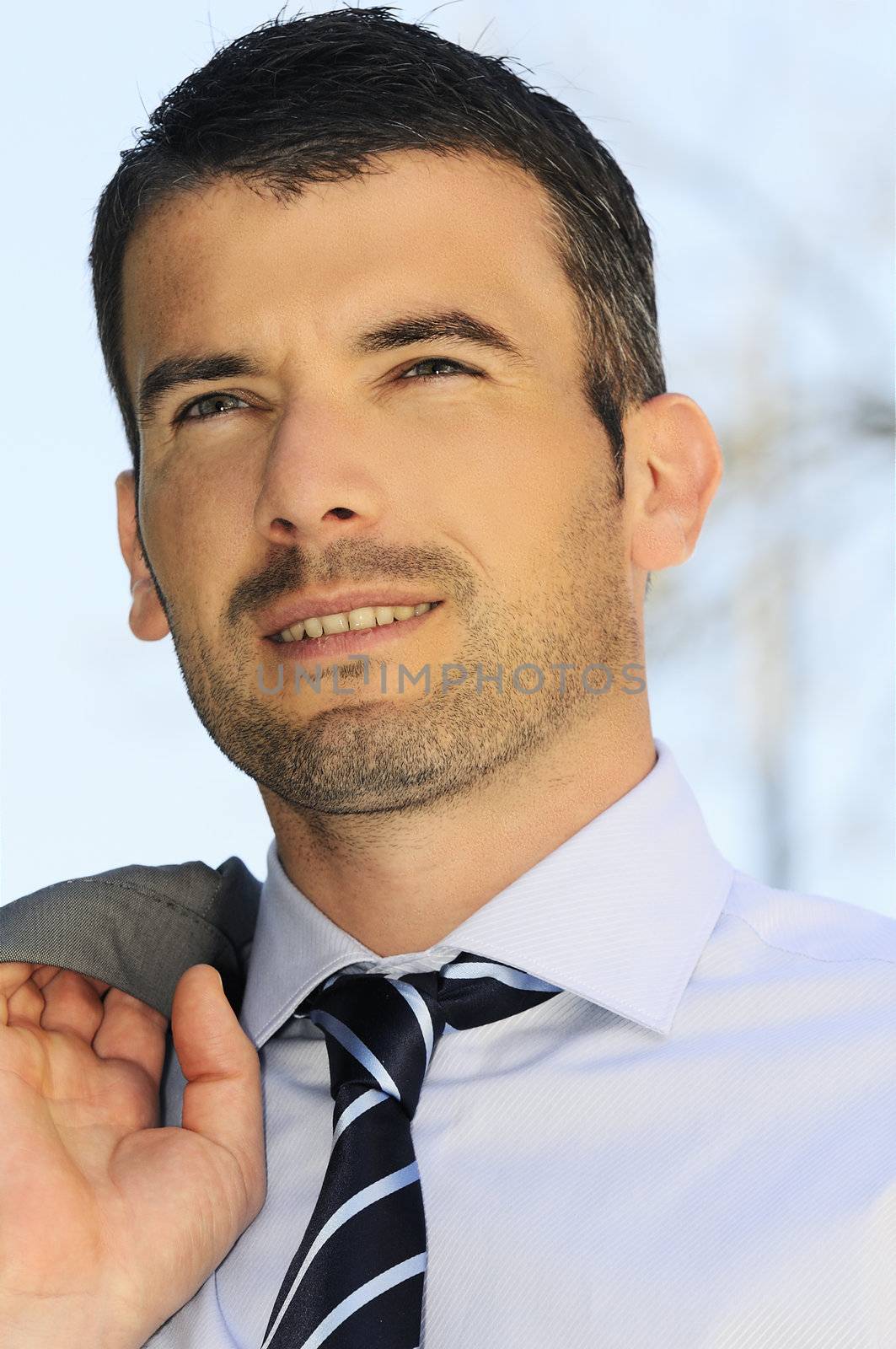 An attractive business man is walking outdoor