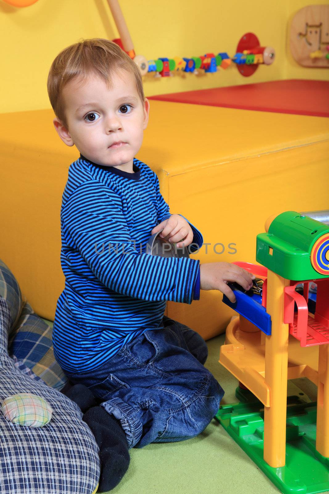 Cute caucasian toddler playing in kindergarten.