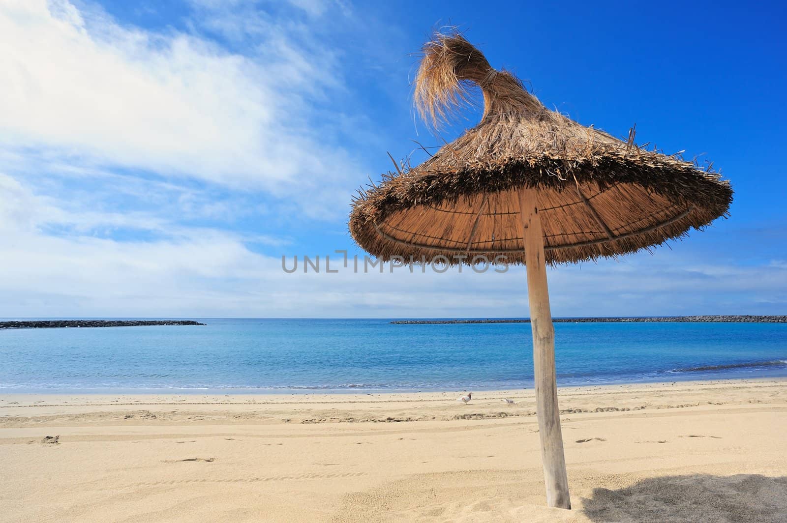 Straw parasol on the sandy sea beach