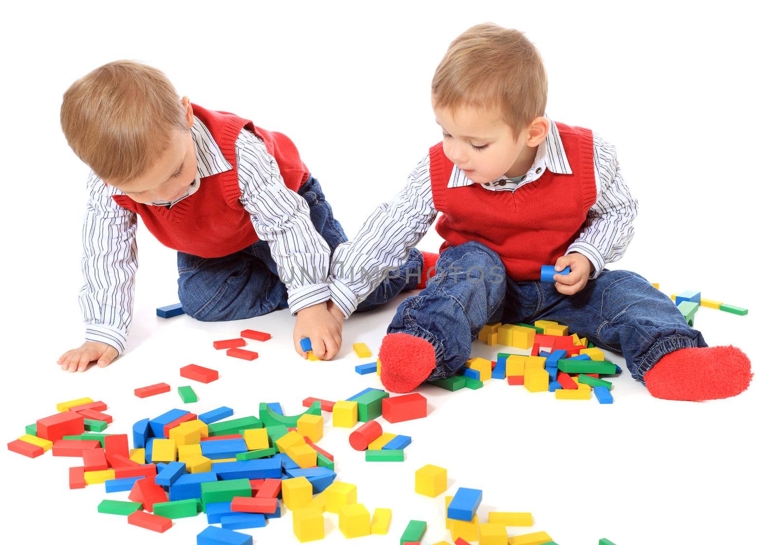 Cute caucasian twin brothers playing. All isolated on white background.