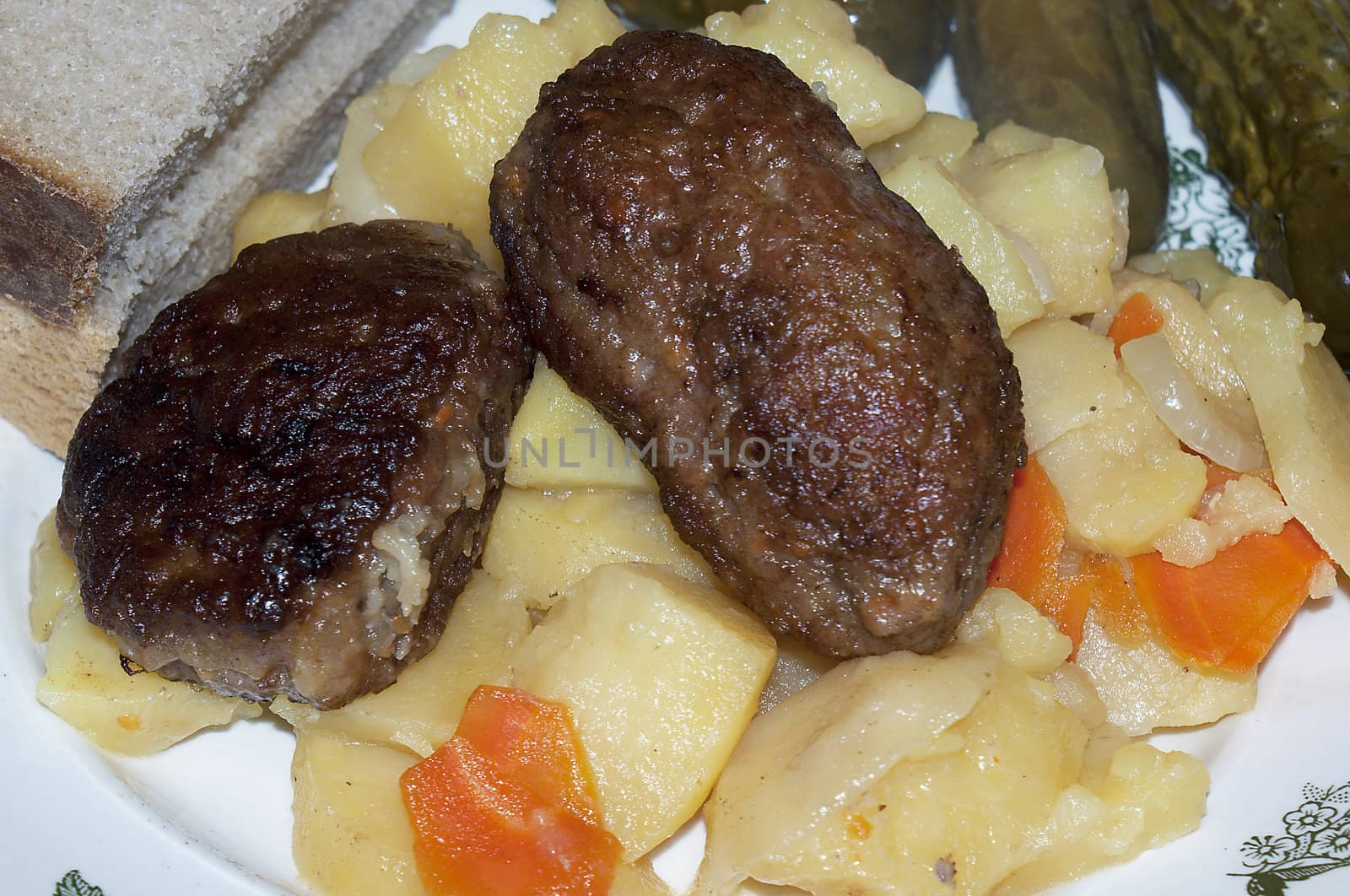 Fried cutlets from young veal with a stewed potato and marinaded cucumbers