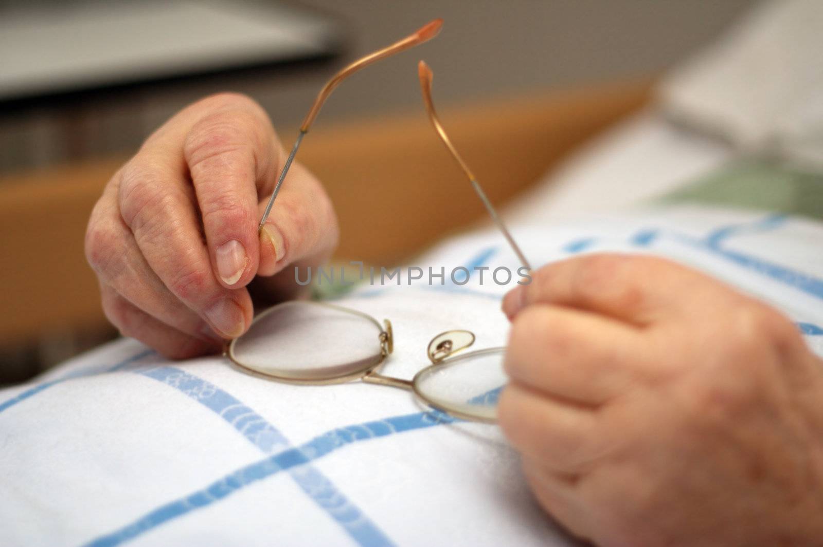 Hands of a care-dependent person holding glasses.