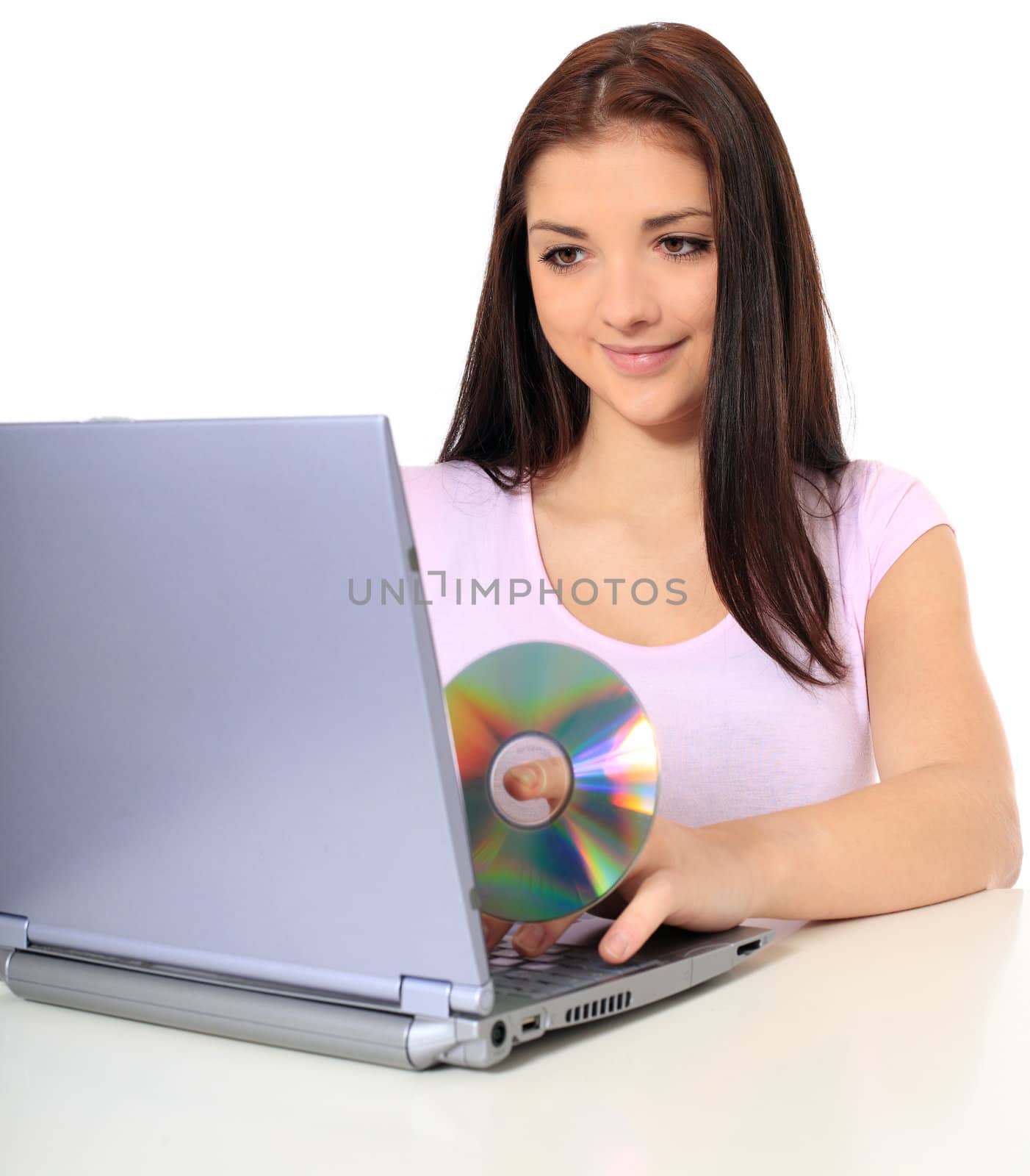 Attractive teenage girl using notebook computer. All on white background.