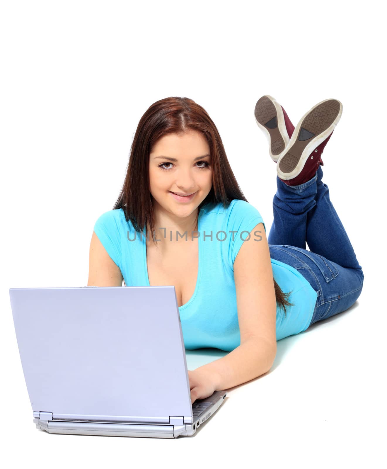 Attractive teenage girl using notebook computer. All on white background.