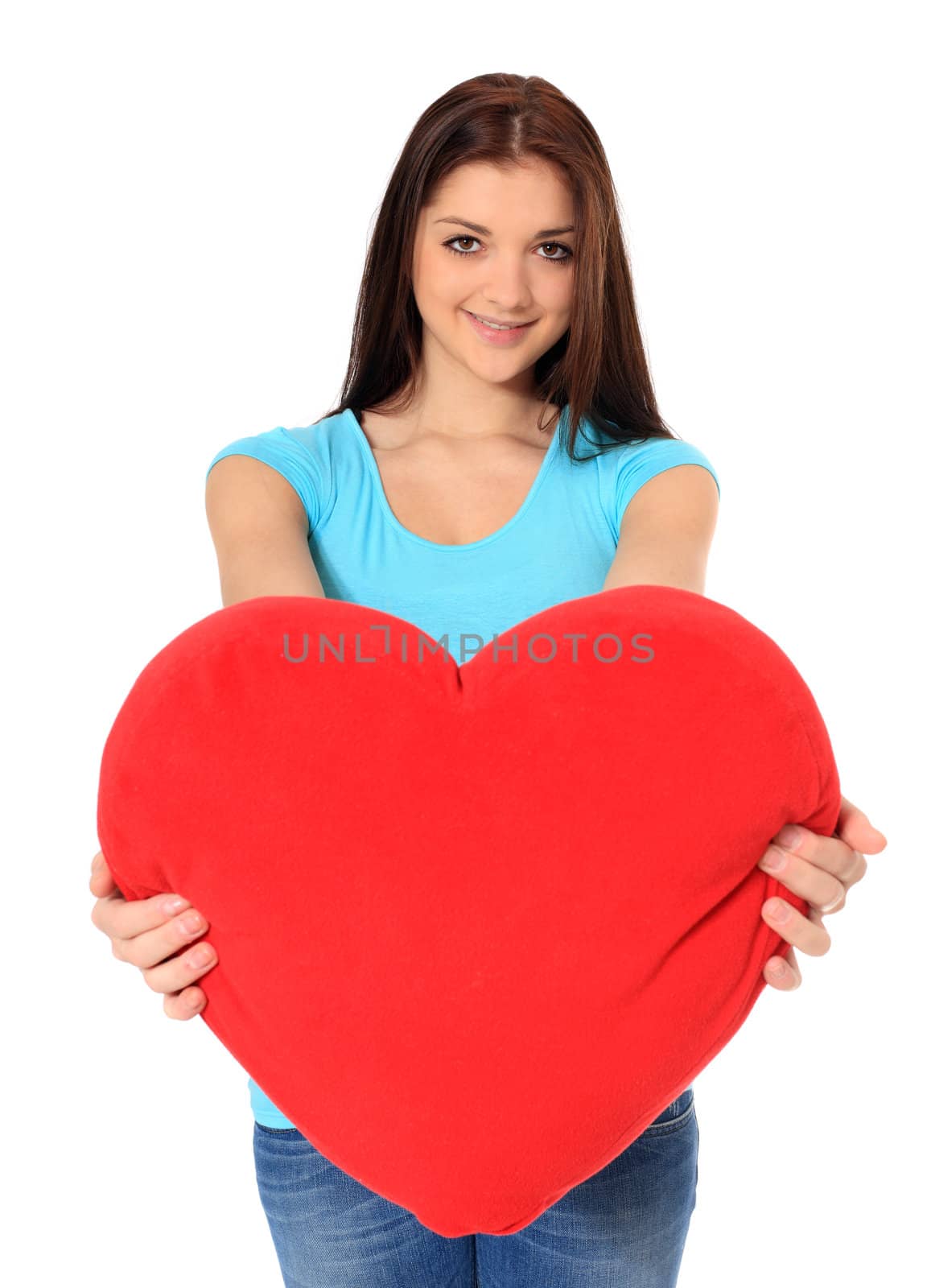 Attractive teenage girl holding red heart-shaped pillow. All on white background.