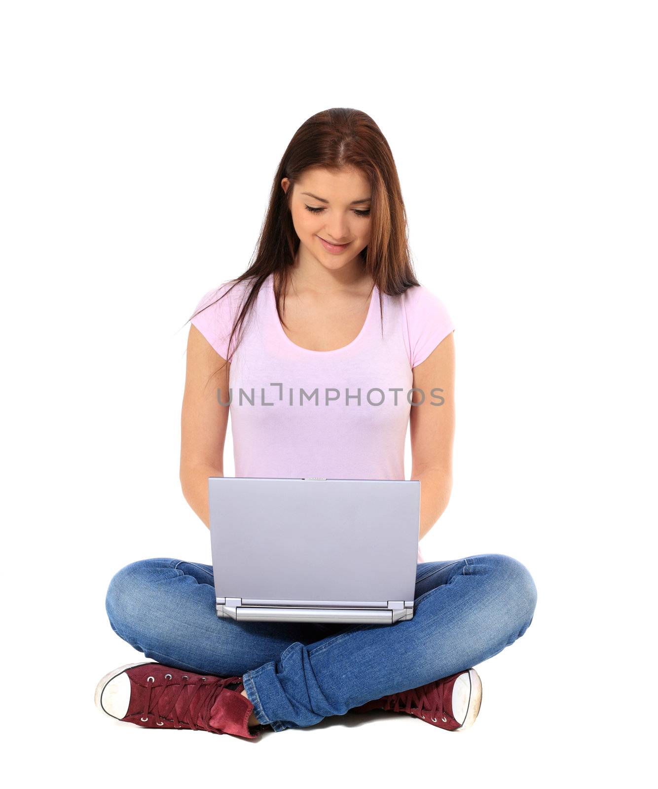 Attractive teenage girl using notebook computer. All on white background.