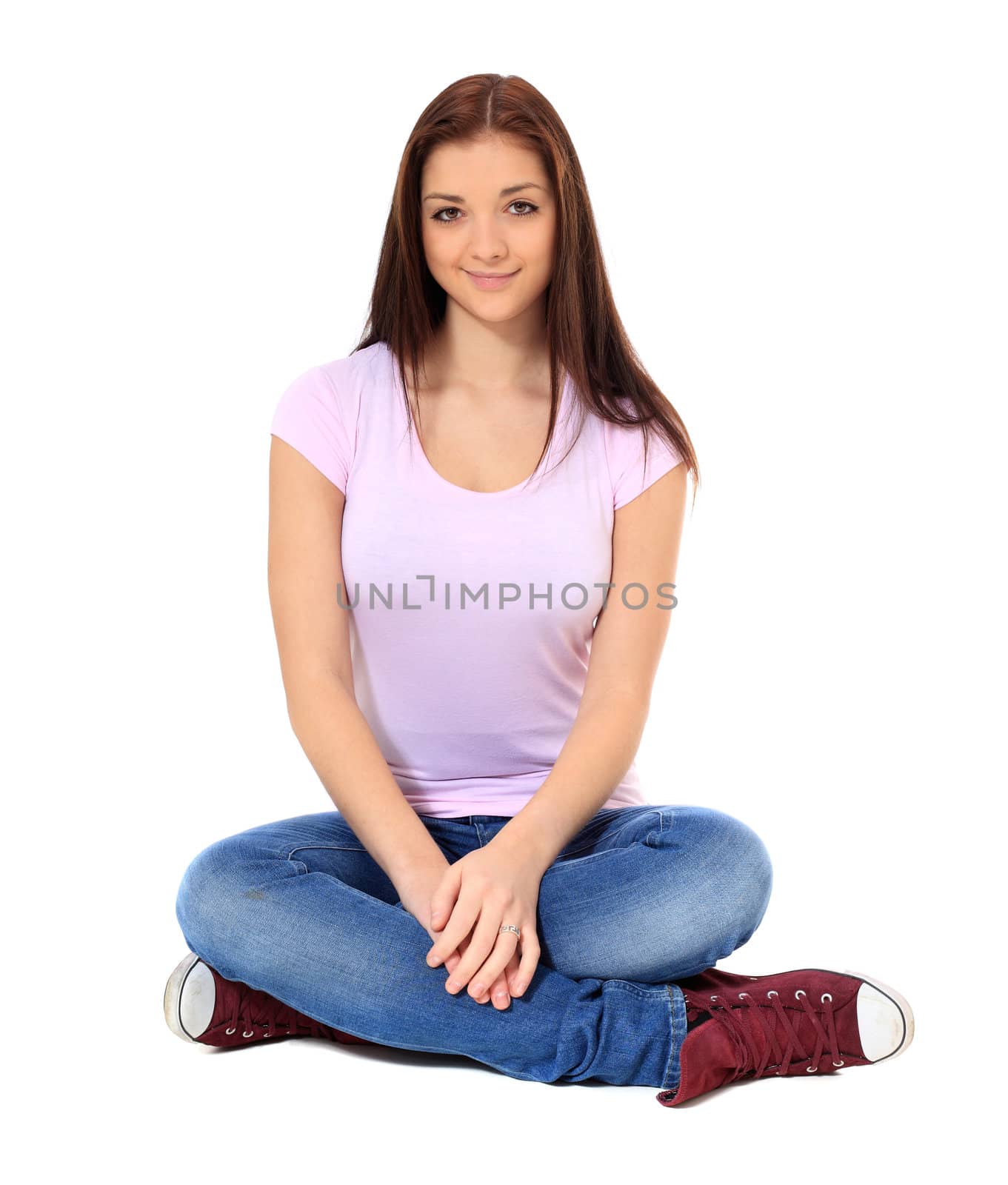 Attractive teenage girl sitting on the floor. All on white background.