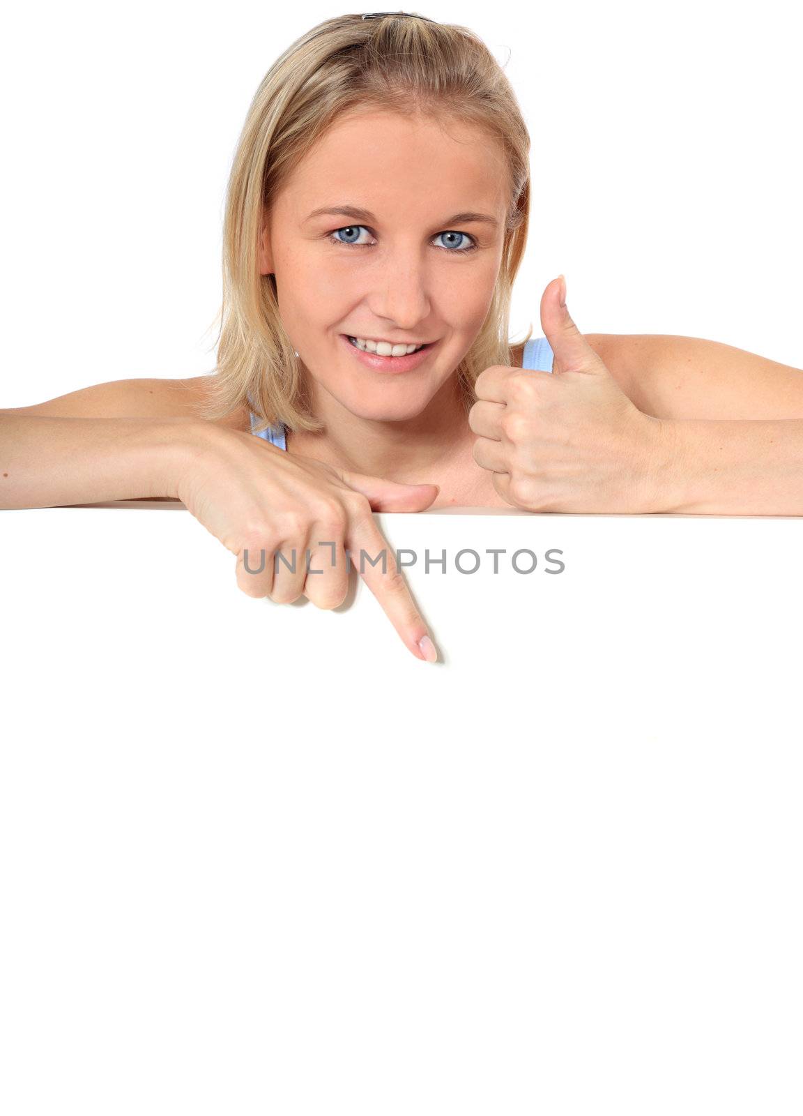 Attractive young scandinavian woman making thumbs up sign and points with finger at white space. All on white background.