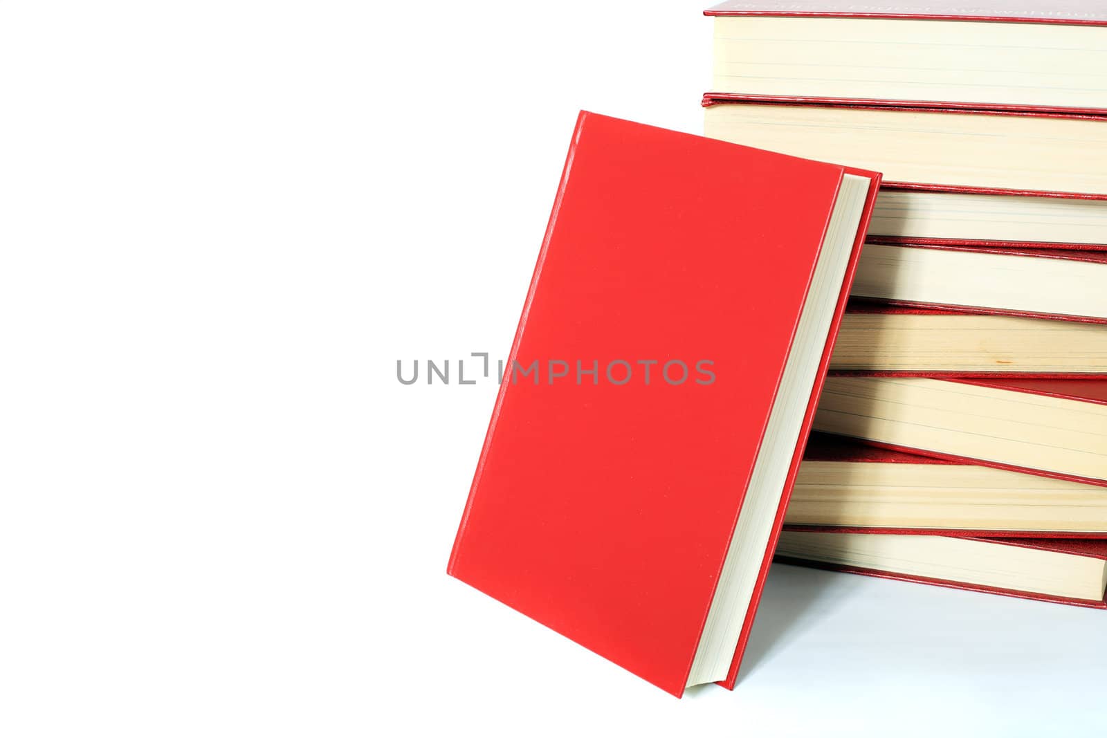 Single book stands next to a pile of books. All on white background. Extra text space on left side.