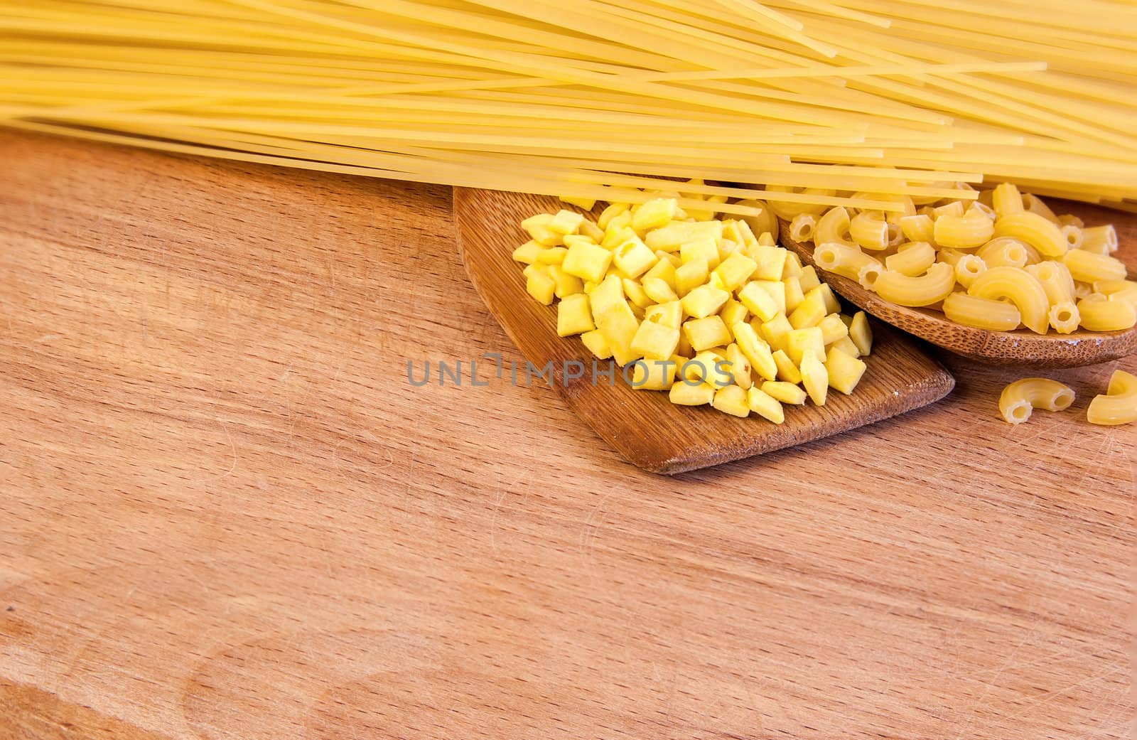 pasta and wooden spoon on a wooden board