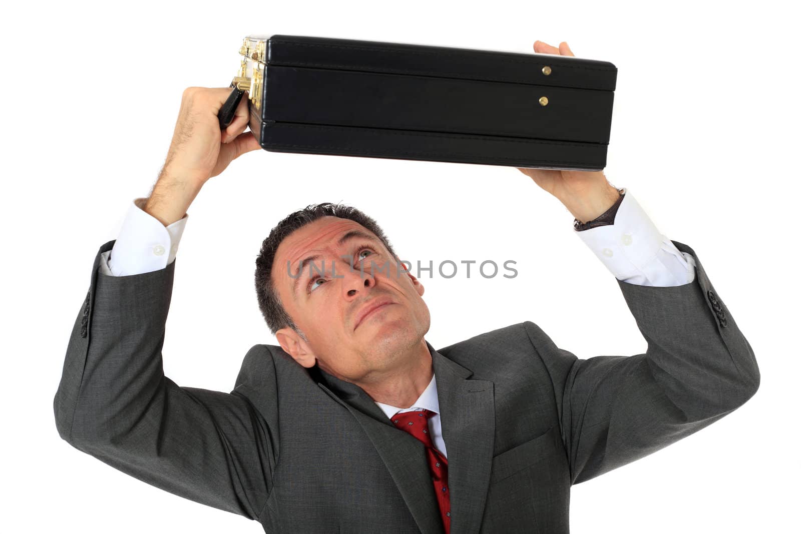 Attractive businessman protecting himself with his briefcase. All on white background.