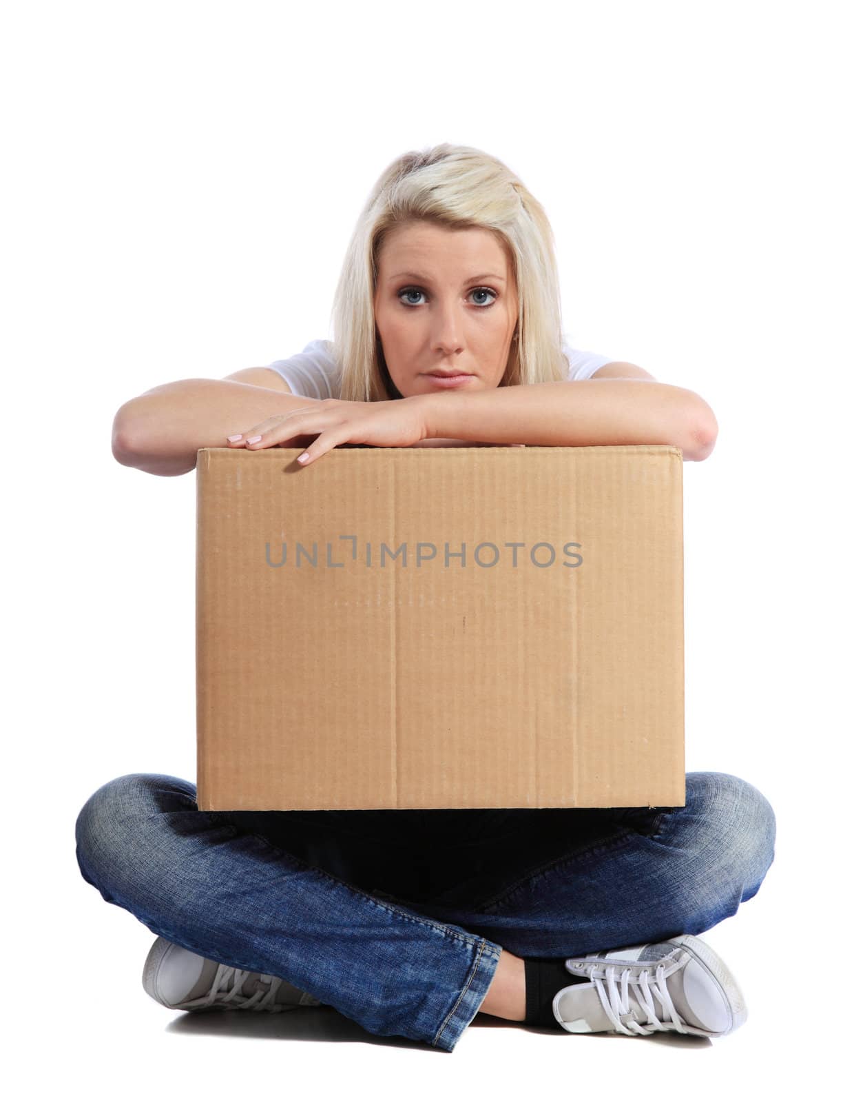 Attractive young woman sitting on floor holding moving box. All on white background.