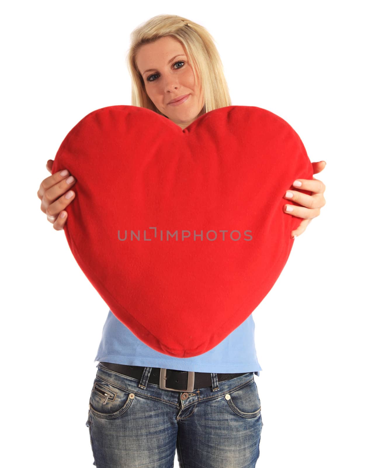 An attractive young woman holding a heart-shaped pillow. All on white background.