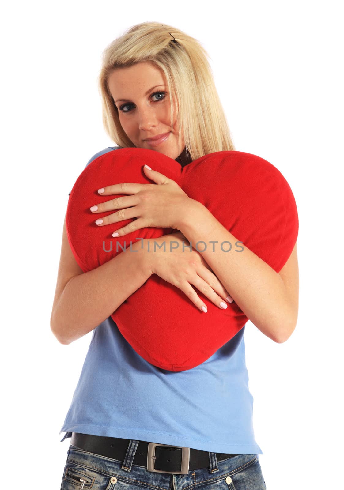 An attractive young woman holding a heart-shaped pillow. All on white background.