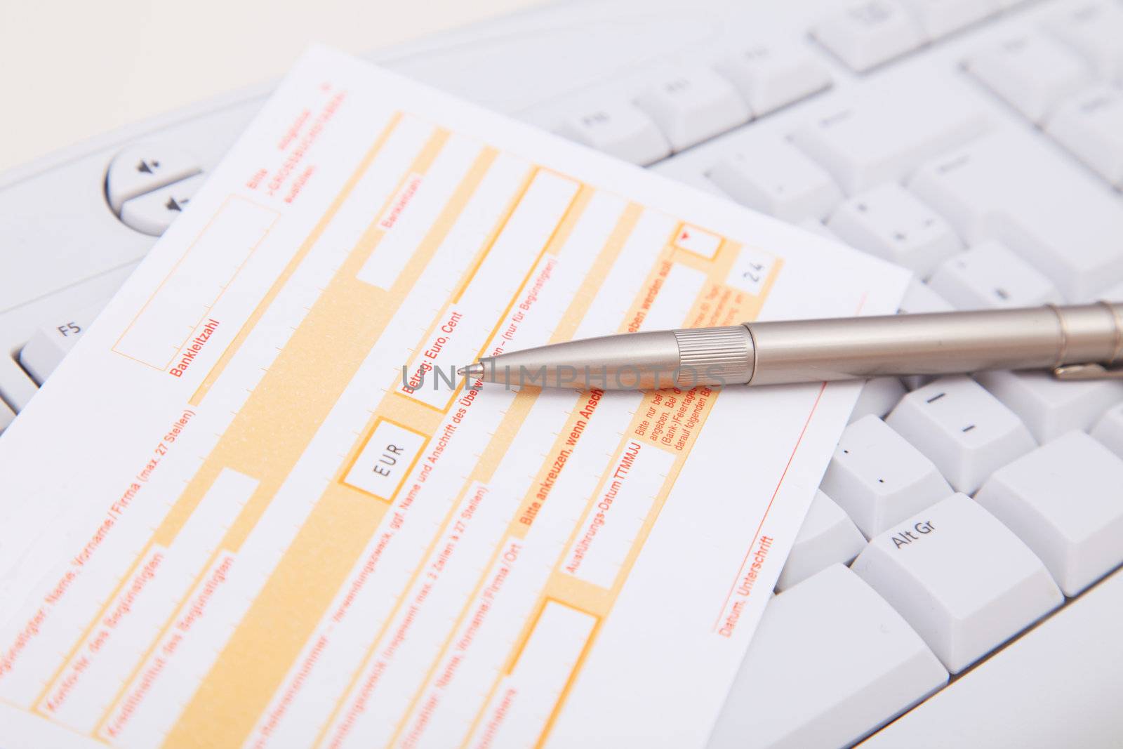 Standard bank transfer form lying on a keyboard.