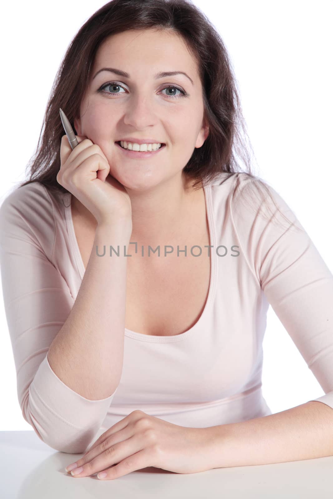 Attractive young woman sitting at a desk. All isolated on white background.