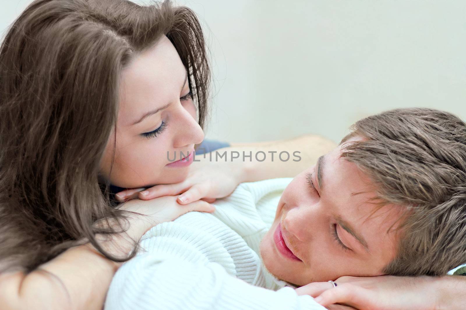 young boy and girl look at each other while lying on bed