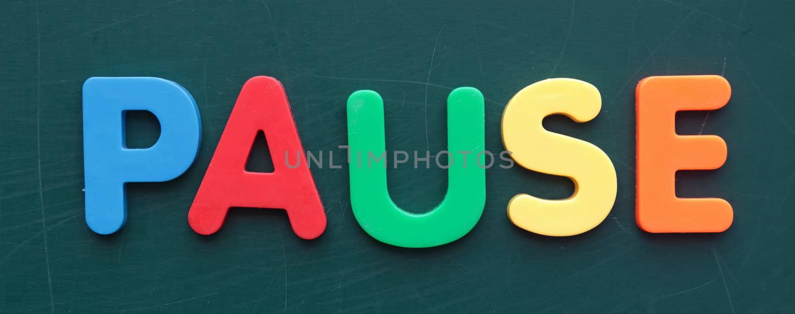 The term pause in colorful letters on a blackboard.