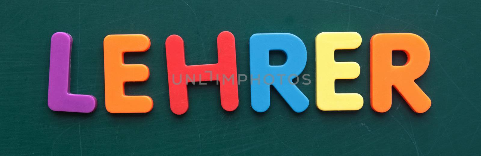 The german term for teacher in colorful letters on a blackboard.