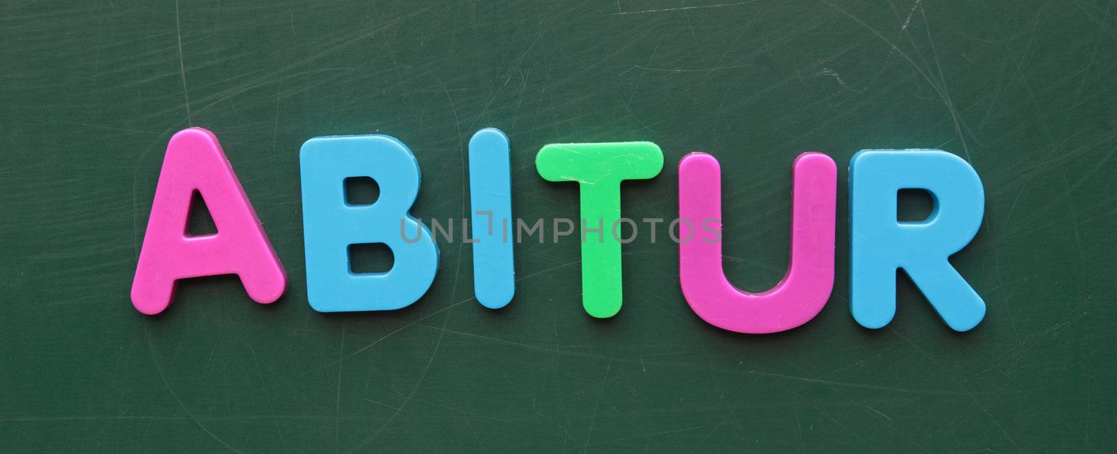 The german term for high-school diploma in colorful letters on a blackboard.