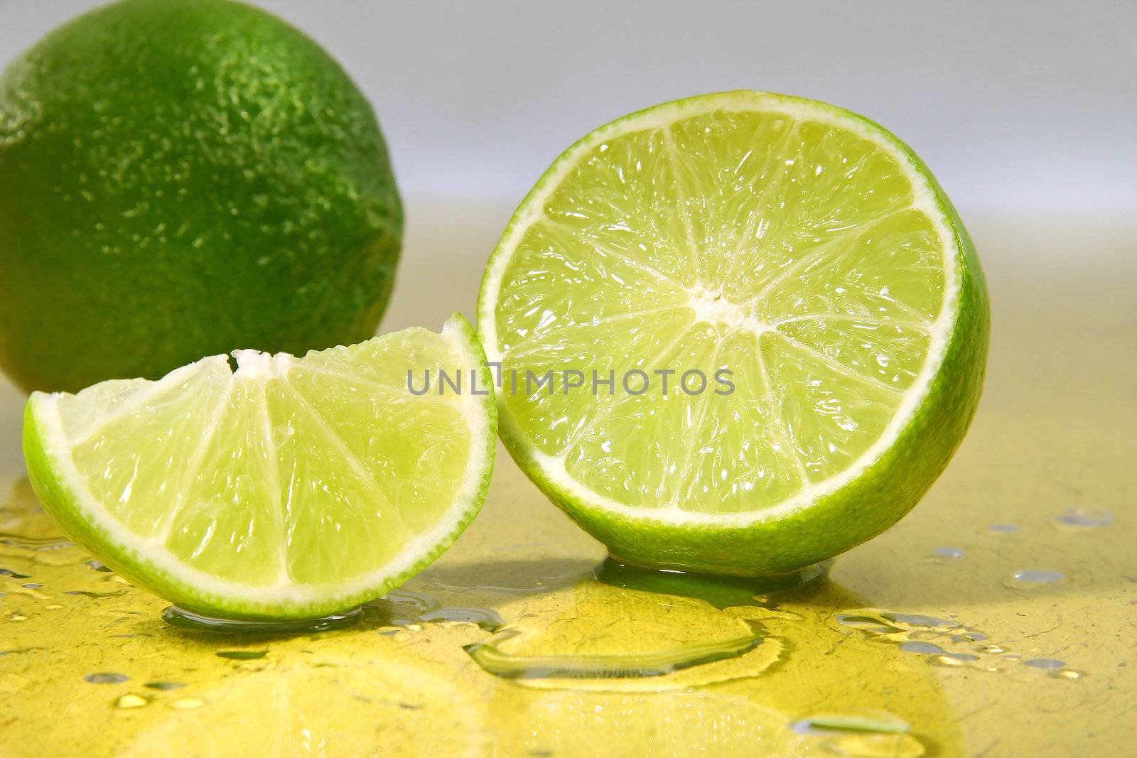 Freshly cut limes  with lime wedge with water droplets