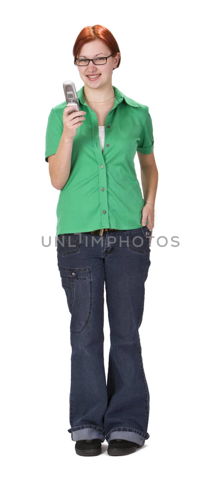 Smiling redheaded girl using a mobile phone while is standing up.