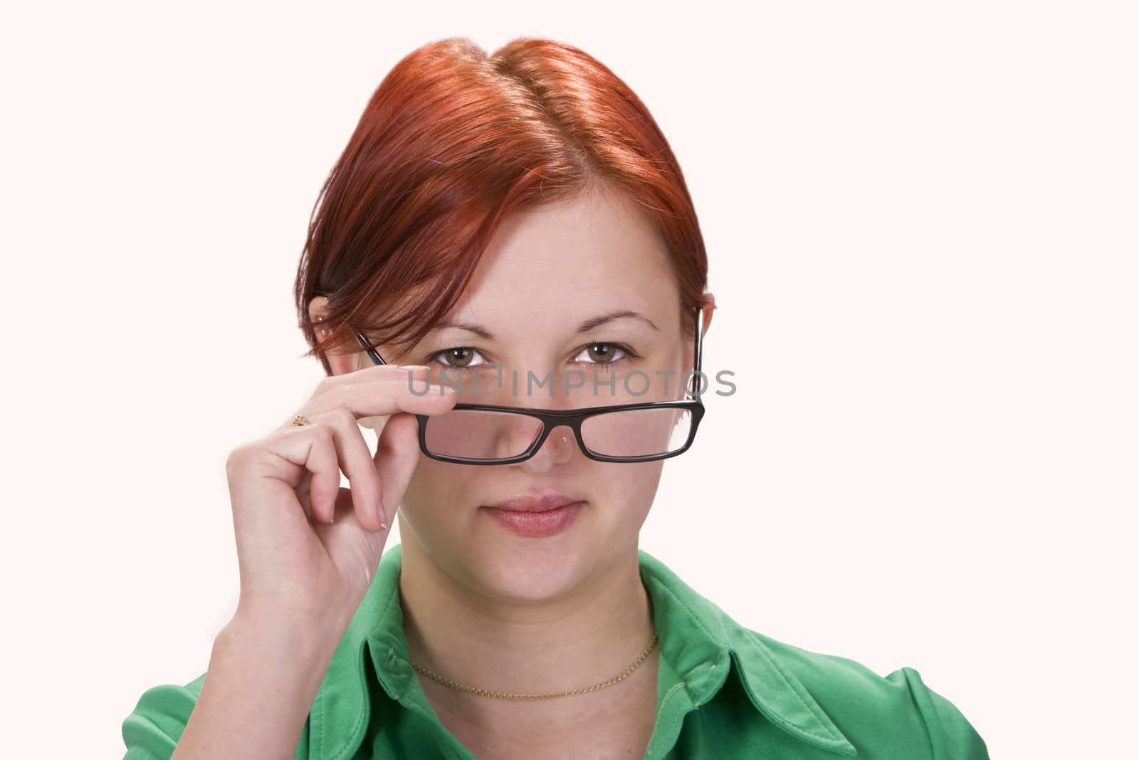 Portrait of a redheaded girl putting on her glasses.