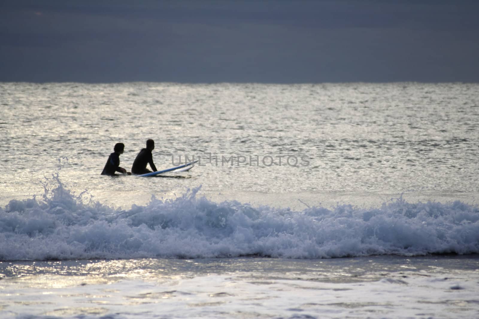 Silhouette of two surfers waiting for the perfect wave.