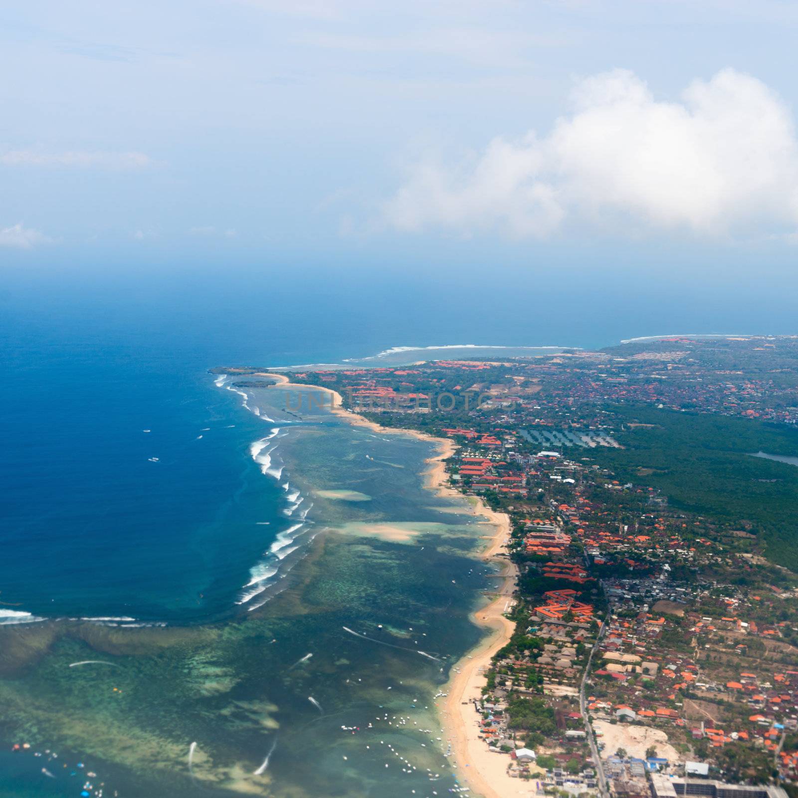 Aerial view of Nusa Dua beach on Bali showing roofs of many hotels and restaurants