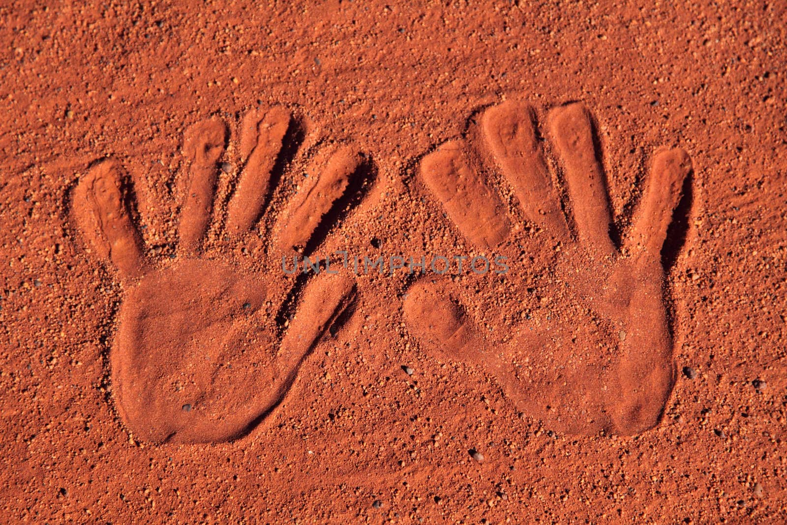 Handprints in typical red sand of central Australia.