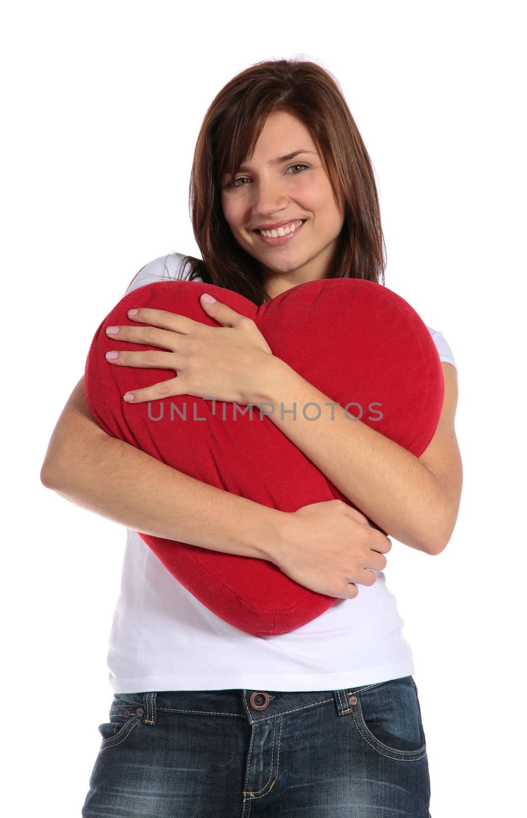 An attractive young woman holding a heart-shaped red pillow. All on white background. 